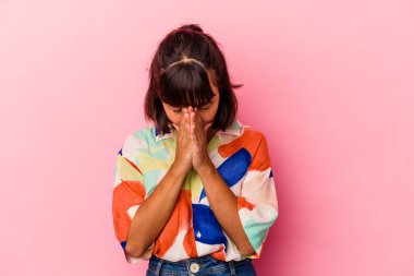 Genç melez kadın pembe arka planda izole edilmiş dua ediyor, bağlılık gösteriyor, dindar biri ilahi ilham arıyor..