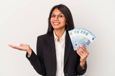 Beyaz arka planda izole edilmiş banknotlar tutan genç Latin bir kadın bir avuç içinde fotokopi alanı ve belinde başka bir el tutan.