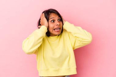 Pembe arka planda izole edilmiş genç Latin bir kadın çığlık atıyor, çok heyecanlı, tutkulu, bir şeyden memnun..