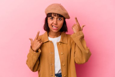 Pembe arka planda izole edilmiş genç melez kadın işaret parmağıyla bir hayal kırıklığı gösteriyor..