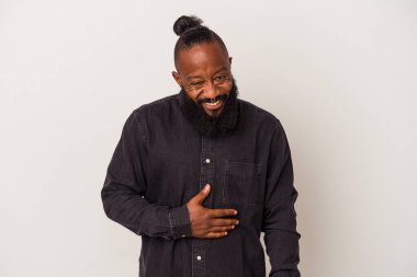 Pembe arka planda sakallı Afrikalı Amerikalı adam karnına dokunuyor, nazikçe gülümsüyor, yemek yiyor ve tatmin oluyor..