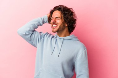 Pembe fırında izole edilmiş genç beyaz adam zaferi, tutkuyu ve coşkuyu kutluyor, mutlu bir ifade..