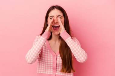 Pembe arka planda izole edilmiş beyaz bir kadın heyecanlı bir şekilde bağırıyor..