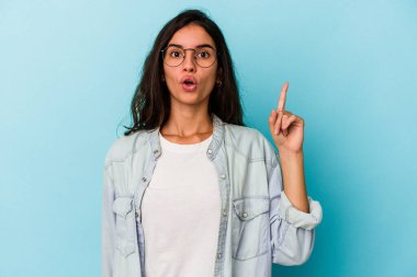 Mavi arka planda izole edilmiş beyaz bir kadın ağzı açık bir şekilde üst tarafı işaret ediyor..