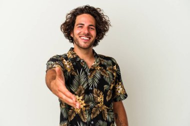 Beyaz arka planda izole edilmiş genç beyaz bir adam selamlama jesti olarak kameraya elini uzatıyor..