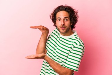 Pembe fırında izole edilmiş genç beyaz adam elleri arasında bir kopya alanı tutarken şok ve hayrete düştü..