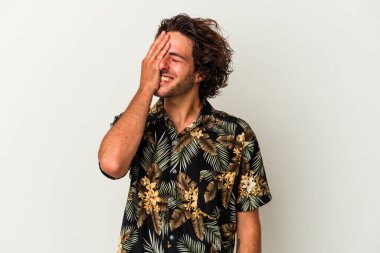 Beyaz arka planda izole olmuş genç beyaz bir adam gülüyor, kaygısız, doğal bir duygu..