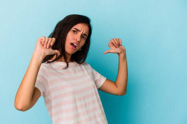 Mavi arka planda izole genç beyaz kadın gururlu ve kendinden emin hissediyor, örnek olarak..