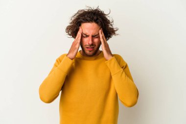 Beyaz arka planda izole olmuş genç beyaz bir adam başı ağrıyor, yüzüne dokunuyor..