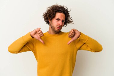 Beyaz arka planda izole edilmiş genç beyaz adam baş parmağını aşağı gösteriyor, hayal kırıklığı konsepti..