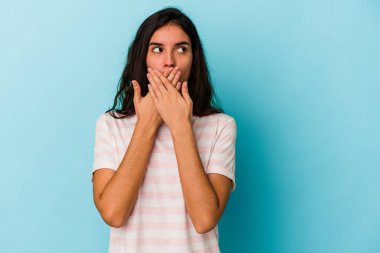 Kafkasyalı genç bir kadın mavi arka planda izole edilmiş düşünceli bir şekilde ağzıyla ağzını kapatan bir fotokopi odasına bakıyor..