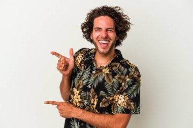 Beyaz arka planda izole edilmiş genç beyaz bir adam işaret parmağıyla fotokopi alanını işaret ederek heyecan ve arzusunu ifade ediyor..