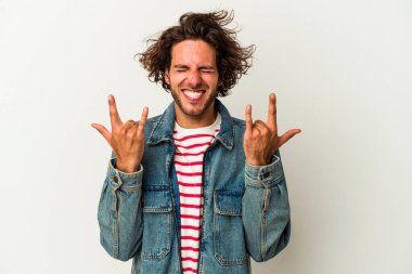 Beyaz arka planda izole edilmiş genç beyaz bir adam boynuzlarını devrim konsepti olarak gösteriyor..