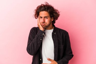 Pembe fırında izole edilmiş genç beyaz adam yanaklarına üflüyor, yorgun bir ifade takınıyor. Yüz ifadesi kavramı.