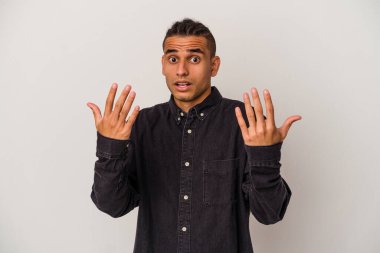 Genç Venezuellalı adam beyaz arka planda izole edilmiş. 10 numarayı elleriyle gösteriyor..