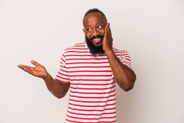 Pembe arka planda sakallı Afrikalı Amerikalı bir adam avuç içinde fotokopi alanı tutuyor, el üstünde tutuyor. Şaşırmış ve mutlu..