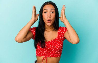 Genç Venezuelalı kadın mavi arka planda izole edilmiş şaşırmış ve şok olmuş..