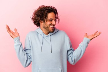 Kafkasyalı genç bir adam pembe fırında yapayalnız, neşeli bir şekilde gülüyor. Mutluluk kavramı.