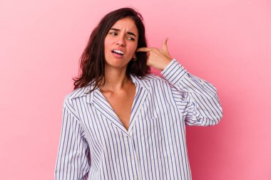 Pembe arka planda izole edilmiş genç beyaz kadın kulaklarını elleriyle kapatıyor..