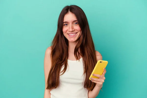 Joven Mujer Caucásica Sosteniendo Teléfono Móvil Aislado Sobre Fondo Azul —  Fotos de Stock