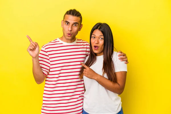 Jong Latijn Paar Geïsoleerd Gele Achtergrond Wijzend Naar Zijkant — Stockfoto