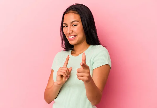 一位年轻的委内瑞拉女子被粉色背景隔离 手指指向前方 — 图库照片