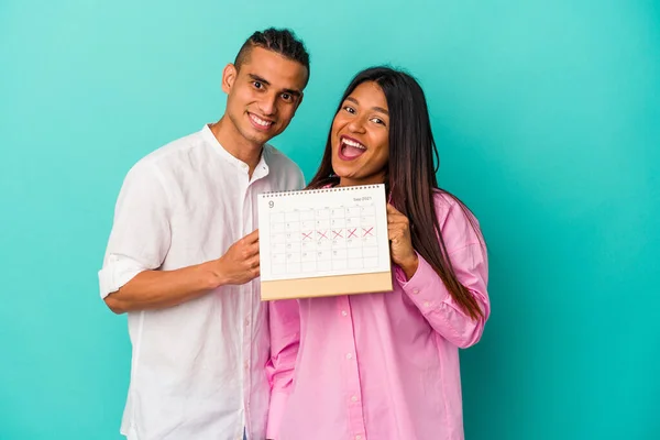 Jong Latijn Paar Met Een Kalender Geïsoleerd Blauwe Achtergrond — Stockfoto