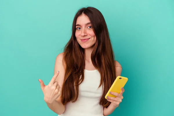 Молодая Белая Женщина Мобильным Телефоном Синем Фоне Указывая Пальцем Тебя — стоковое фото