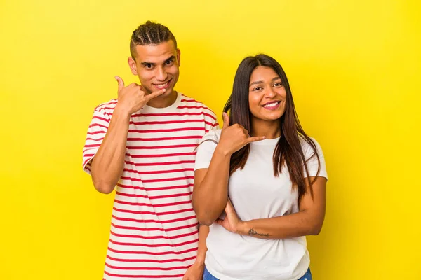 Jong Latijn Paar Geïsoleerd Gele Achtergrond Tonen Een Mobiele Telefoon — Stockfoto