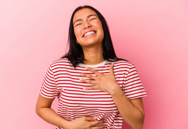 ピンクの背景に孤立した若いベネズエラの女性は喜んで笑い 胃の上に手を保つ楽しみを持って — ストック写真