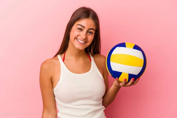 若いです白人女性保持していますバレーボールボール孤立ピンクの背景幸せな 笑顔と陽気な — ストック写真