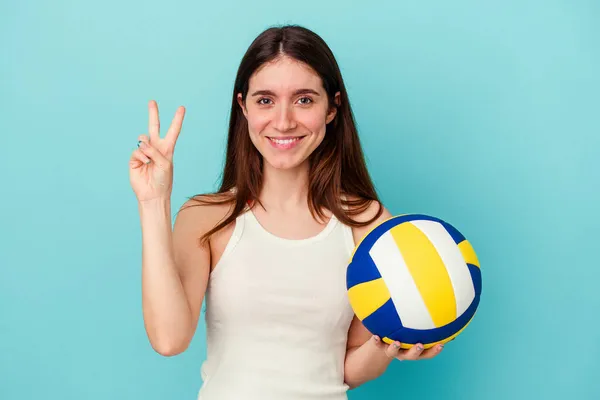 Молода Біла Жінка Грає Волейбол Ізольовано Синьому Фоні Показуючи Номер — стокове фото