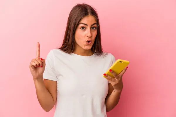 Joven Mujer Caucásica Sosteniendo Teléfono Móvil Aislado Sobre Fondo Rosa — Foto de Stock