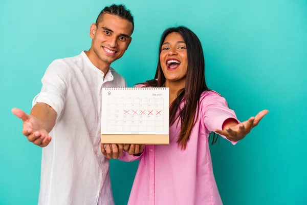 Jong Latijn Paar Met Een Kalender Geïsoleerd Blauwe Achtergrond — Stockfoto