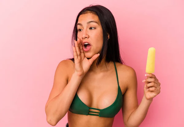 若いベネズエラの女性はピンクの背景叫びに隔離されたアイスクリームを保持し 口を開けた近くに手のひらを保持 — ストック写真