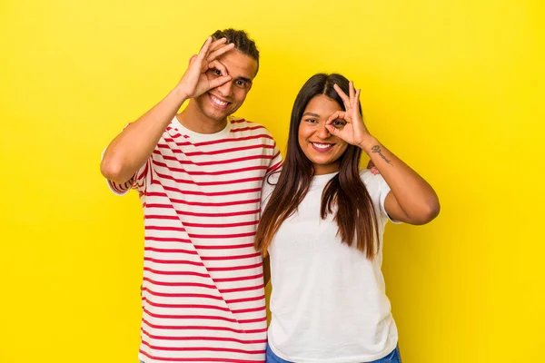 Jovem Casal Latino Isolado Fundo Amarelo Animado Mantendo Gesto Olho — Fotografia de Stock