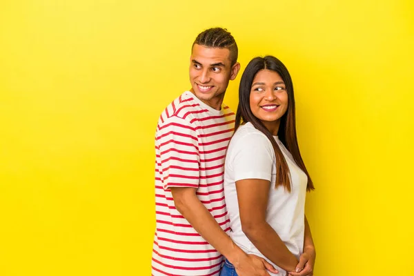 Jovem Casal Latino Isolado Fundo Amarelo Olha Para Lado Sorridente — Fotografia de Stock