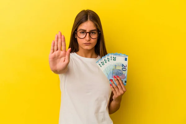 Mladá Běloška Drží Bankovky Izolované Žlutém Pozadí Nataženou Rukou Ukazující — Stock fotografie