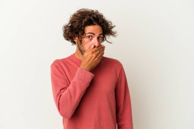 Beyaz arka planda izole edilmiş genç beyaz bir adam ağzı kapalı ve elleri endişeli görünüyor..