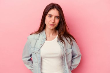 Pembe arka planda soyutlanmış beyaz bir kadın üzgün, ciddi bir yüz, mutsuz ve hoşnutsuz..