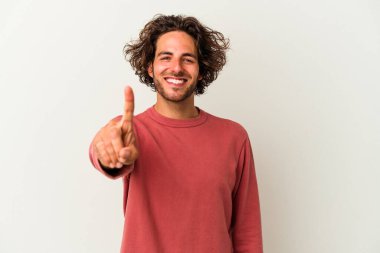 Beyaz arka planda izole edilmiş beyaz tenli genç bir adam bir numarayı parmağıyla gösteriyor..