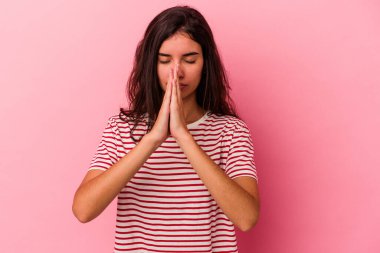 Pembe arka planda izole edilmiş genç beyaz kadın dua ediyor, bağlılık gösteriyor, dindar biri ilahi ilham arıyor..