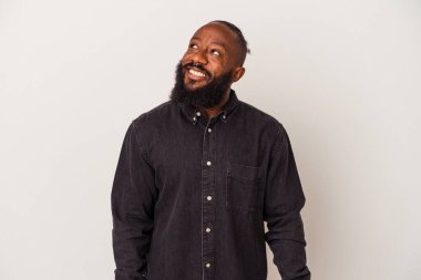 Sakallı Afro-Amerikan bir adam pembe arka planda izole edilmiş rahat ve mutlu bir şekilde gülüyor, boynunda dişlerini gösteriyor..