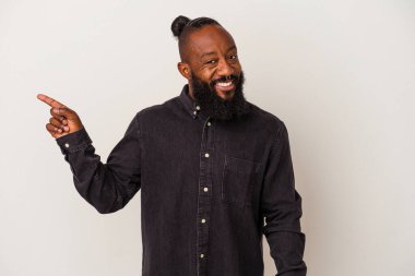 Pembe arka planda sakallı, neşeli gülümseyen, işaret parmağıyla işaret eden Afrikalı Amerikalı bir adam..