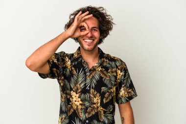 Beyaz arka planda izole genç beyaz adam heyecanlı tamam göz jesti tutmak.