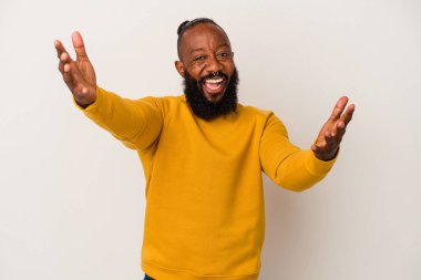 Pembe arka planda sakallı Afrikalı Amerikalı bir adam zaferi ya da başarıyı kutlarken şaşırdı ve şok oldu..