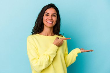 Mavi arka planda izole edilmiş beyaz bir kadın. Elinde palmiye ağacının fotokopisini tutarken heyecanlı..