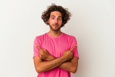 Beyaz arka plan noktalarında izole genç beyaz adam, iki seçenek arasında seçim yapmaya çalışıyor.