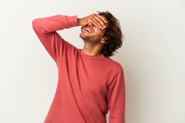 Beyaz arka planda izole olmuş genç beyaz bir adam ellerini başının üstünde tutarak neşeyle gülüyor. Mutluluk kavramı.