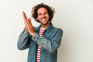 Beyaz arka planda izole olmuş genç beyaz bir adam enerjik ve rahat hissediyor, ellerini ovuşturuyor..